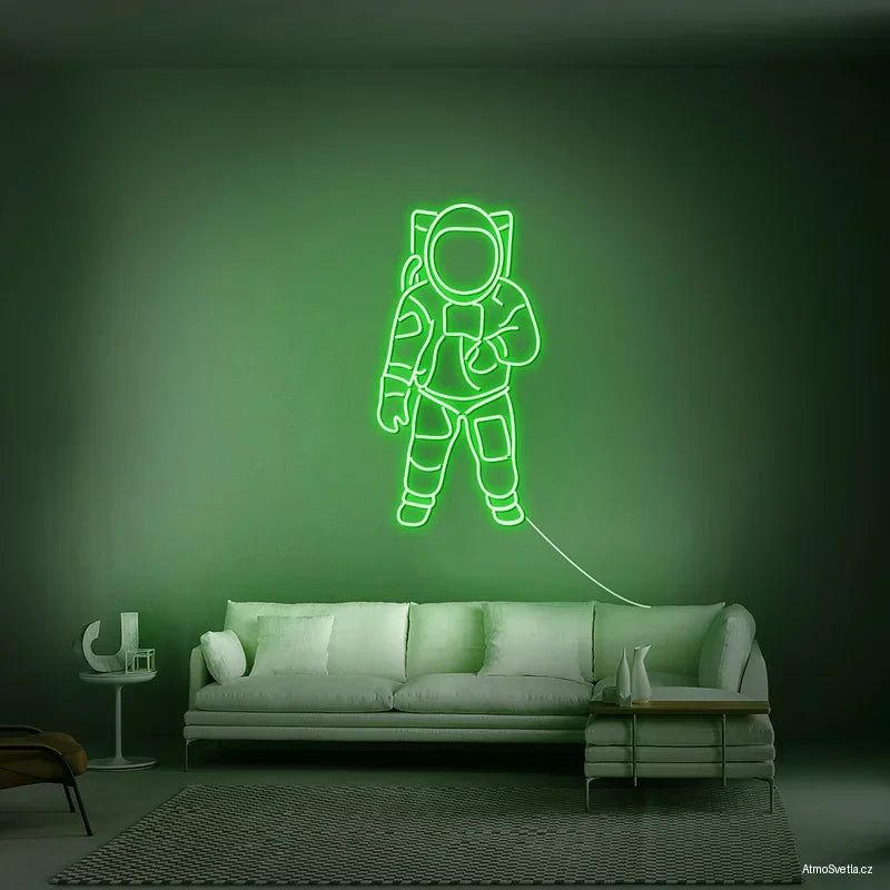 Zelený neonový nápis astronaut, kreativní světelný dekor pro moderní byt.