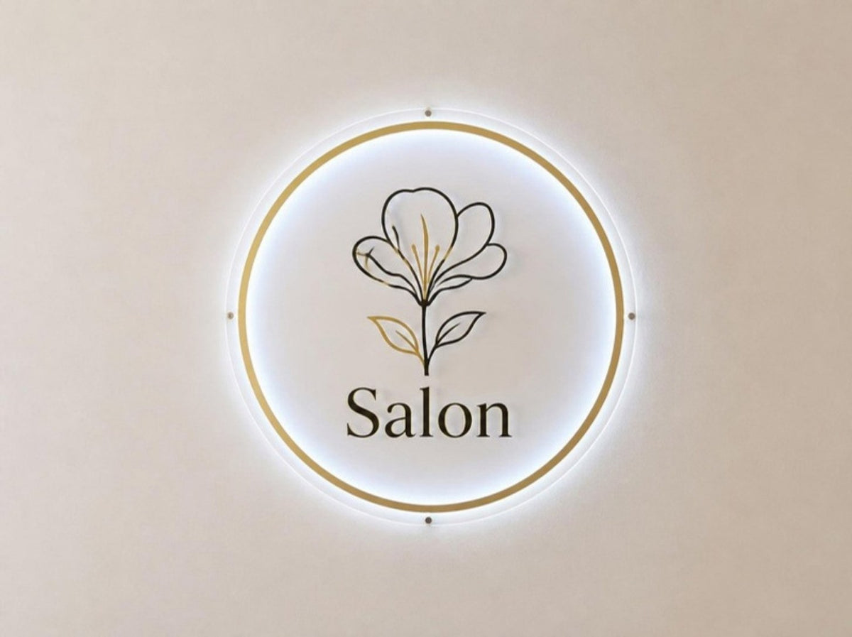 Podsvícené logo salonu na zdi recepce