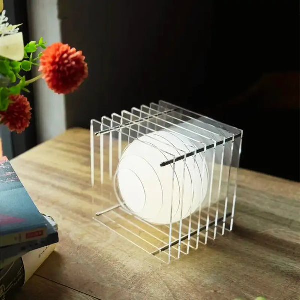 Stolní lampa CubeVision s čirými akrylovými panely a kulovým LED světlem.