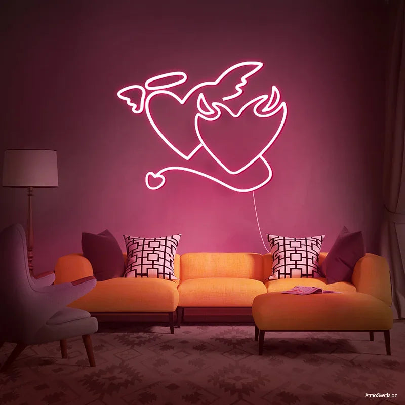 Romantický LED neon anděl a ďábel v růžové barvě osvětlující růžovou stěnu a oranžovou pohovku.